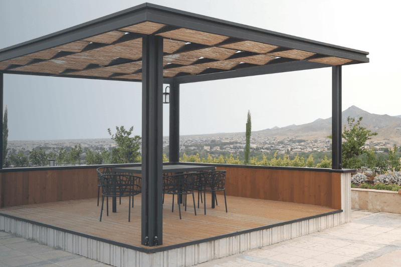 aluminum pergola above a patio with a table and chairs