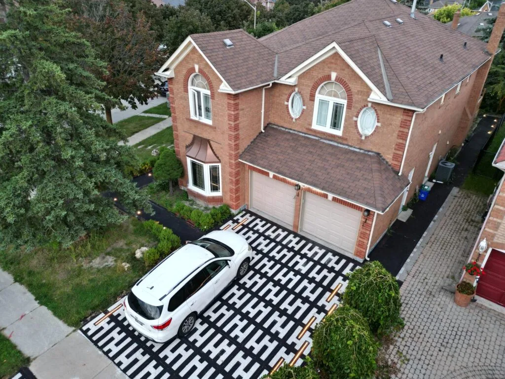 aerial photo of a house with a heated driveway and a white SUV parked on it