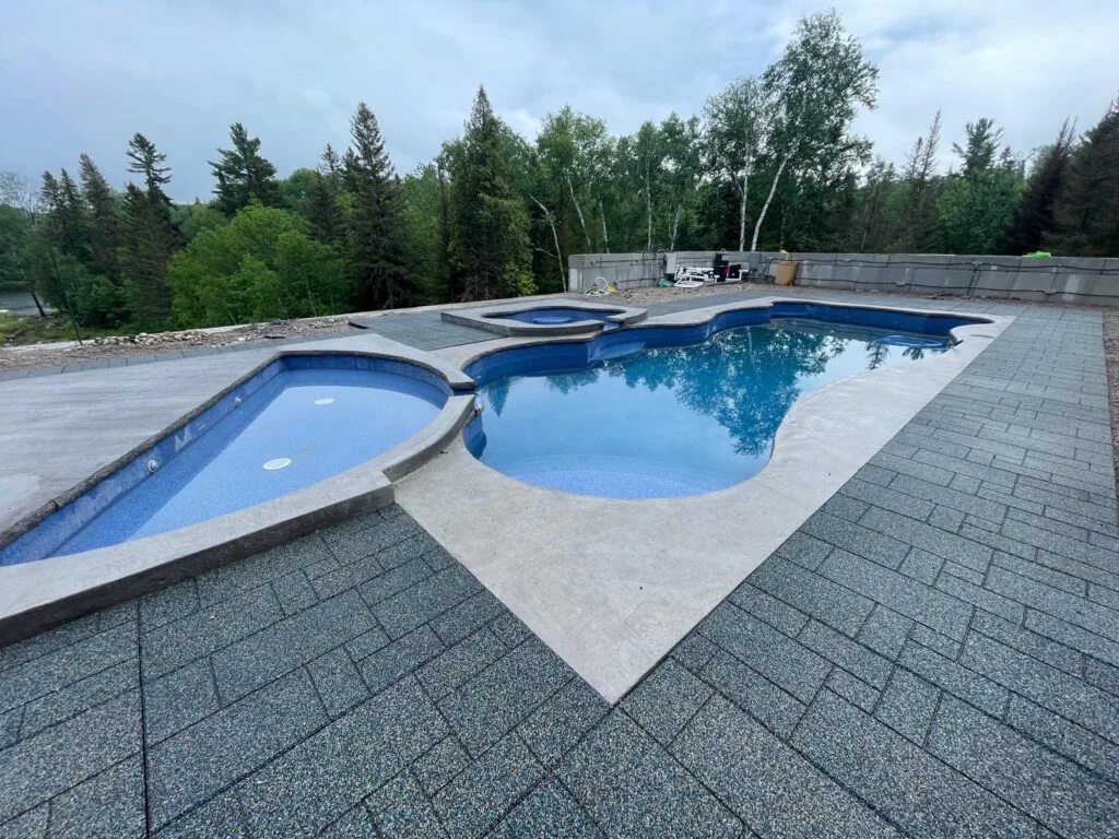 interlocking surrounding an outdoor asymmetrical pool