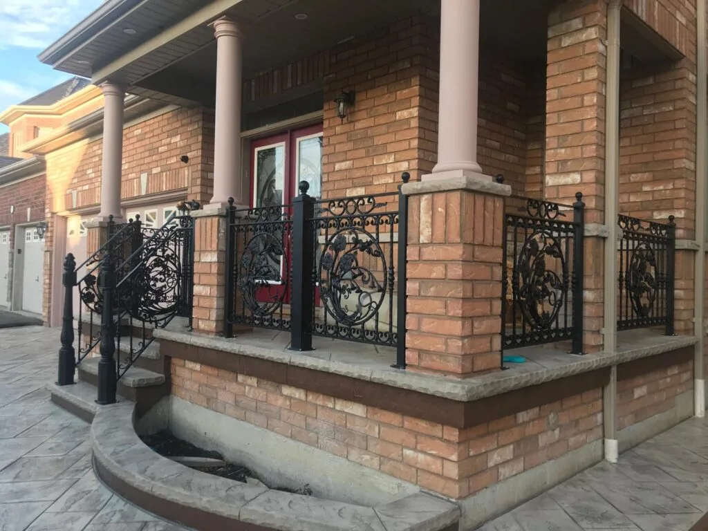 front balcony with black metal railings surrounding the balcony and stairs