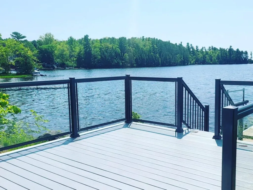 glass railings surrounding a cottage dock in front of a lake